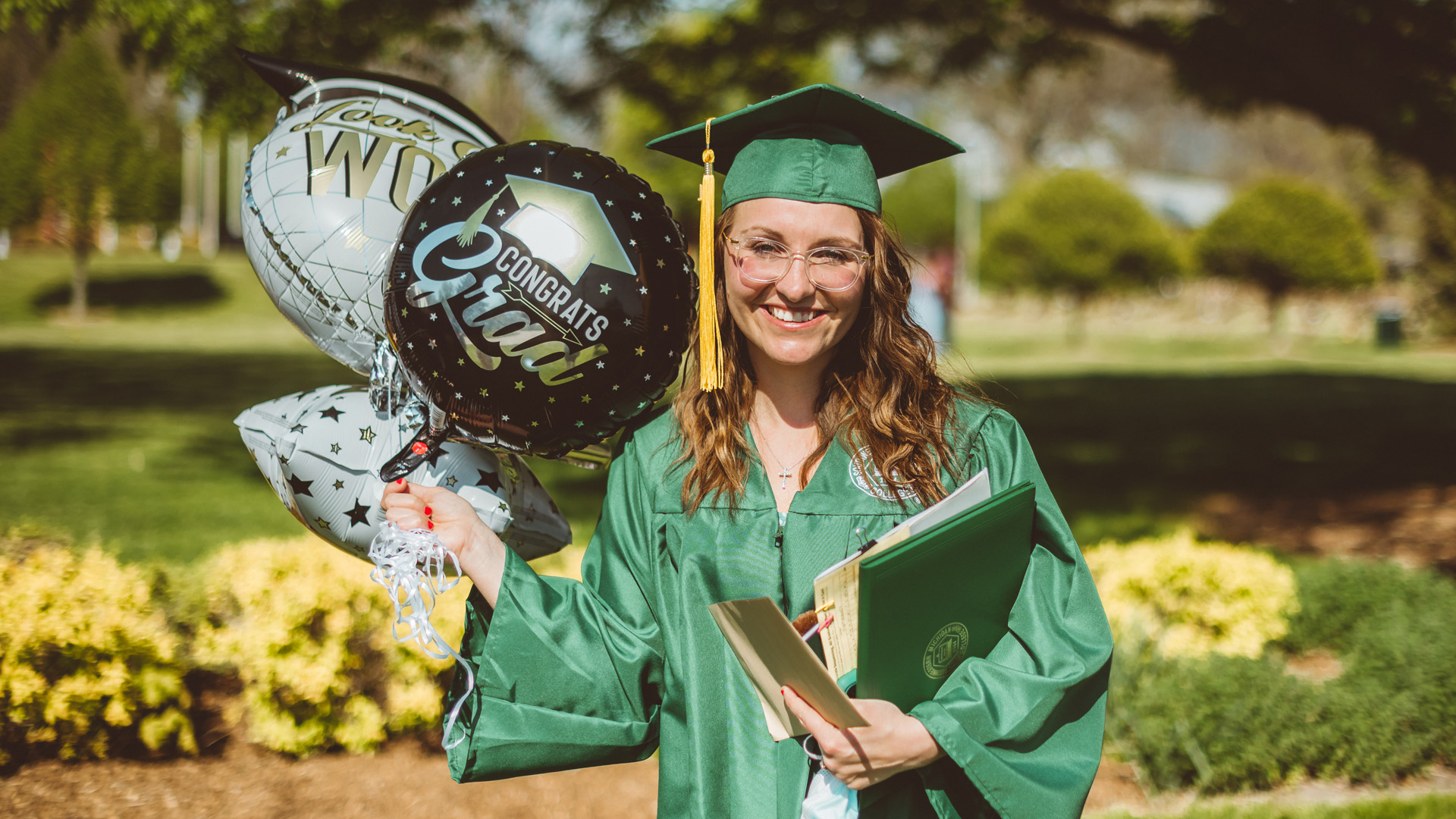 Photo of graduating student holding balloons