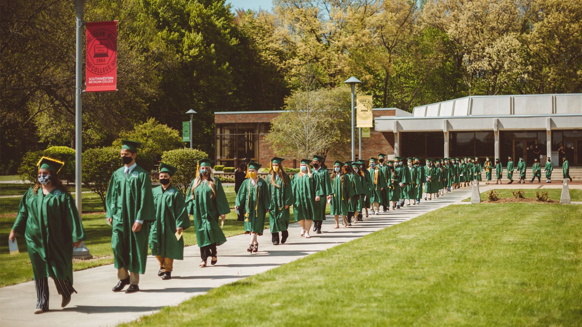 Graduating students lining up to walk outsite the library