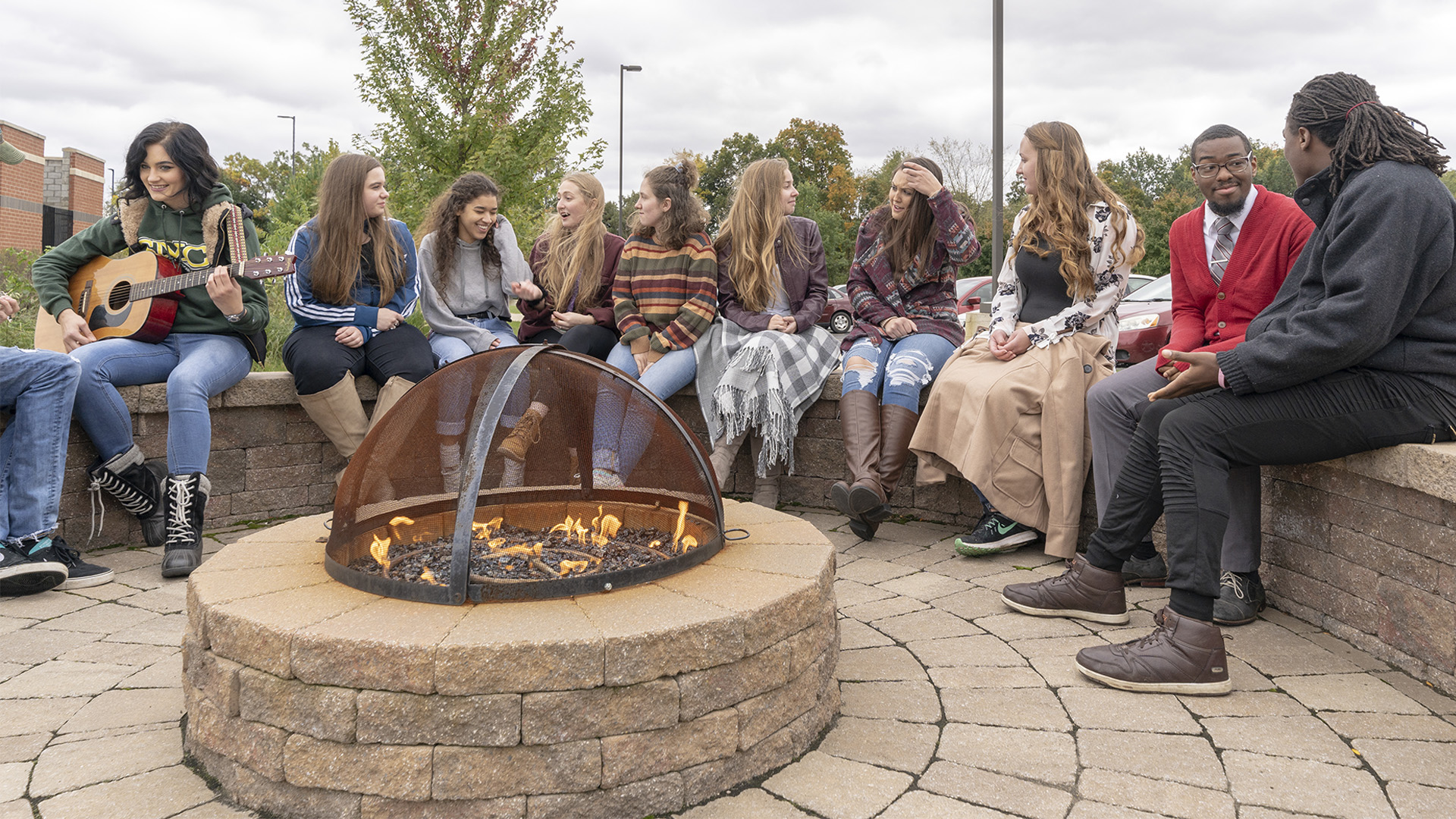 Students sitting around the residence halls firepit