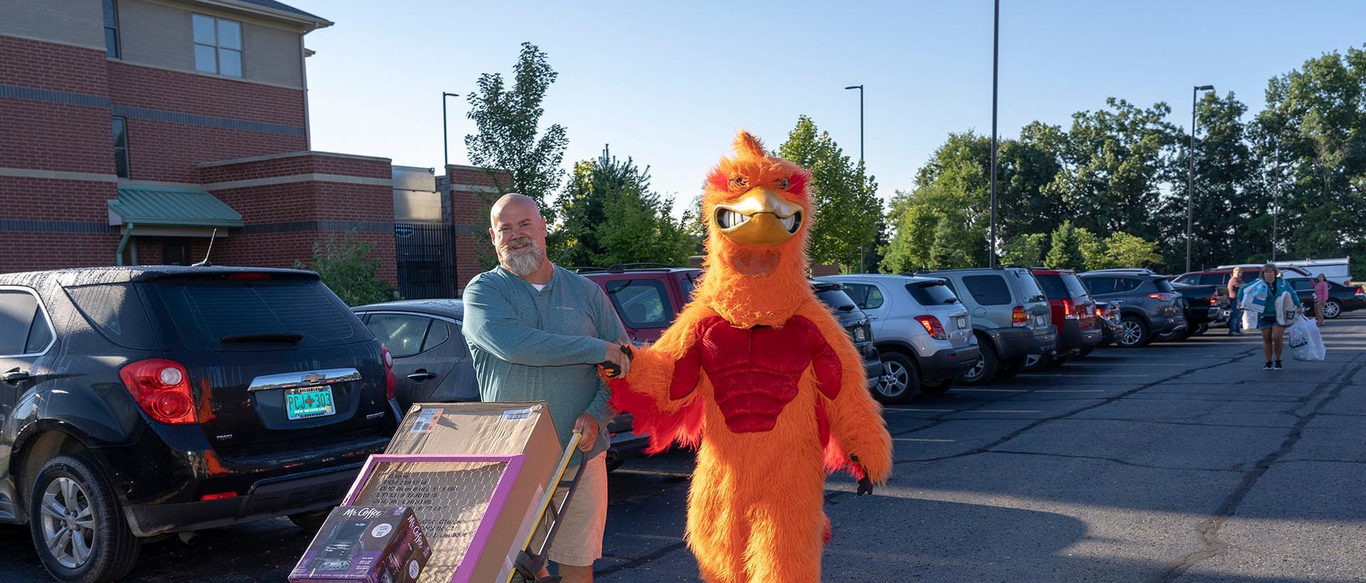 A parent shaking hands with the roadrunner mascot