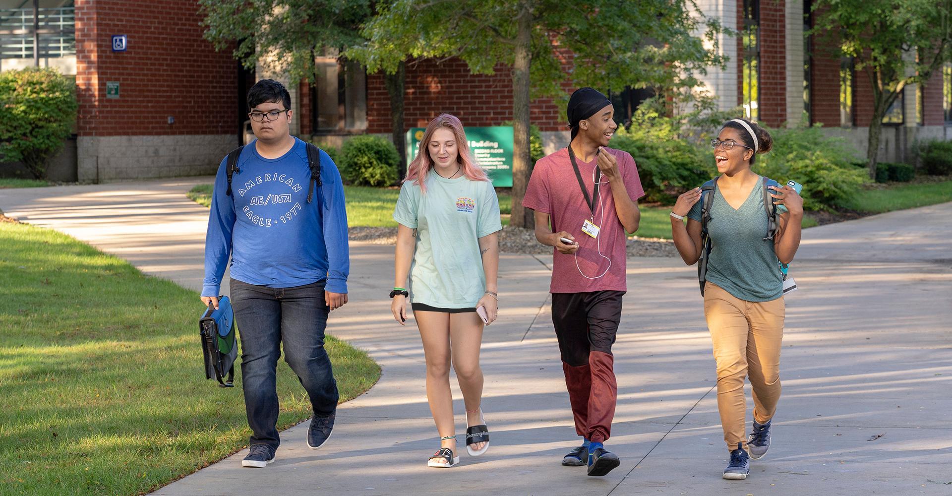 Four students walking across campus