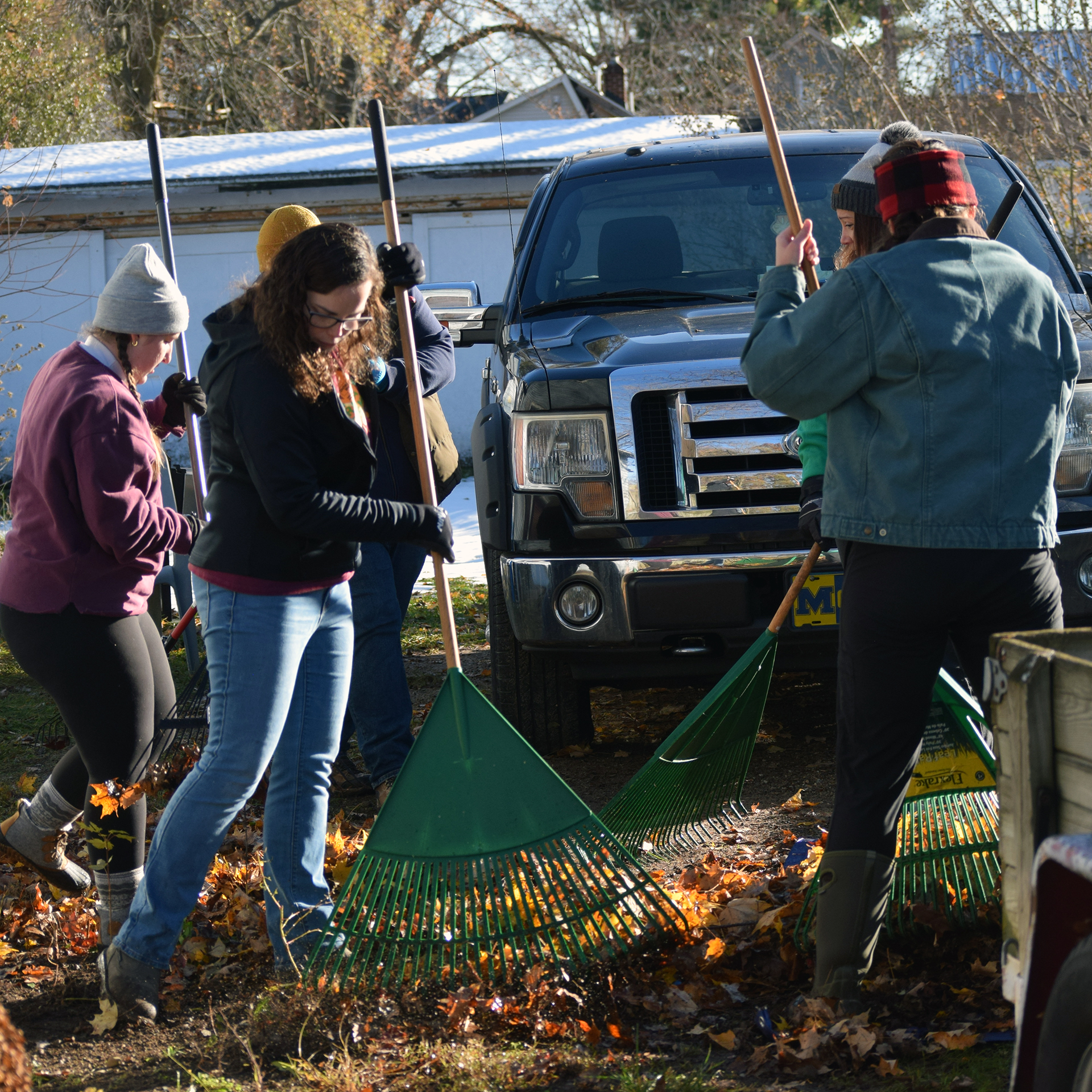 Staff members rake on James Street in Dowagiac